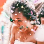 Wedding guests throwing petals to the bride and groom.